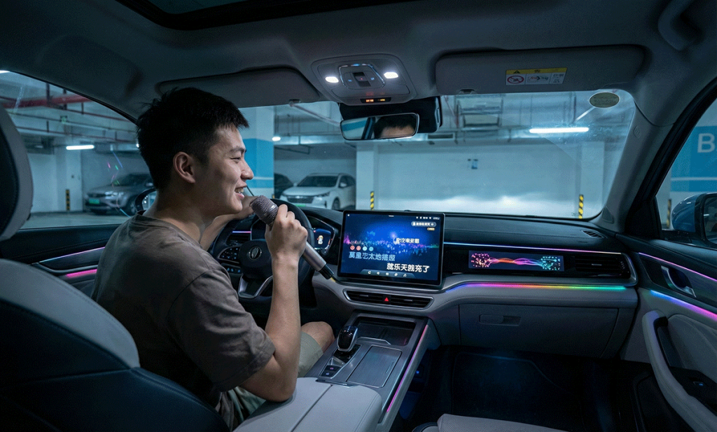A young man singing karaoke with a microphone inside a parked Chinese electric vehicle in an underground garage.