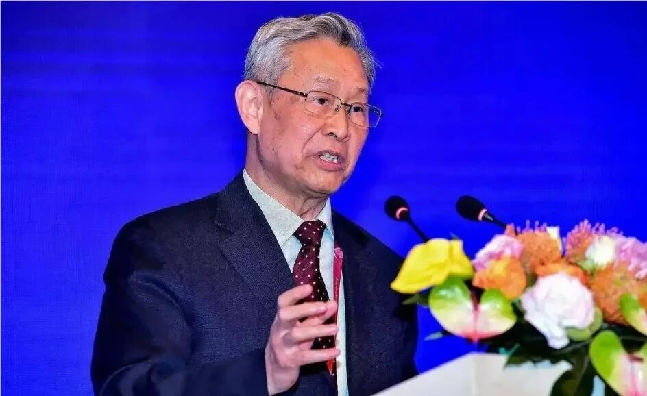 Elderly Chinese scientist Du Xiangwan standing in front of a modern waste-to-energy plant