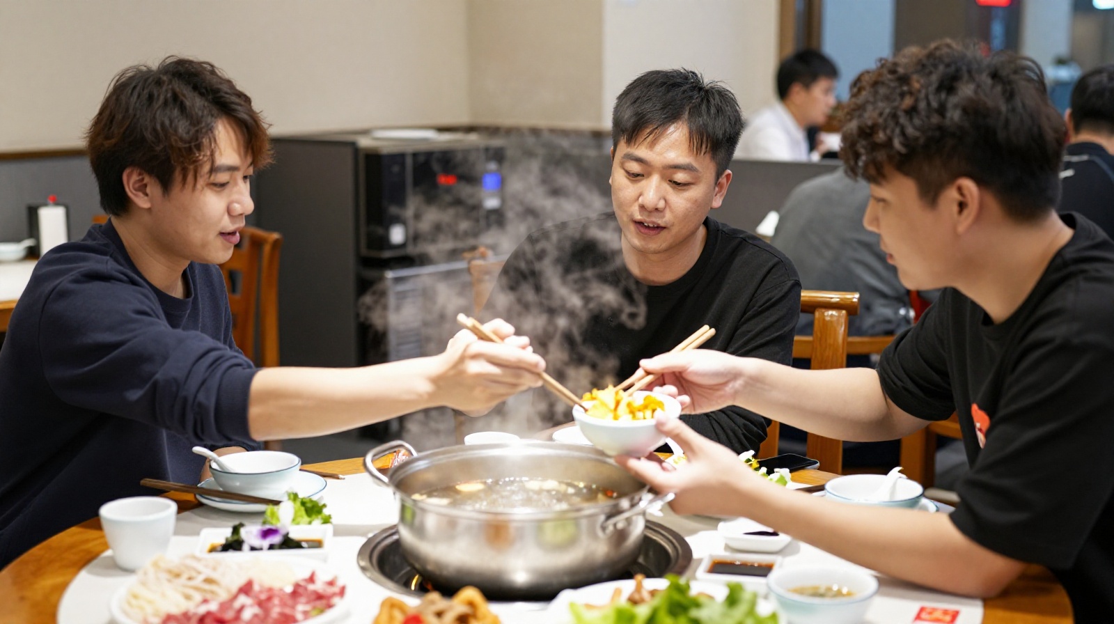 Three young professionals sharing food and laughing together at a hot pot dinner table in Beijing.