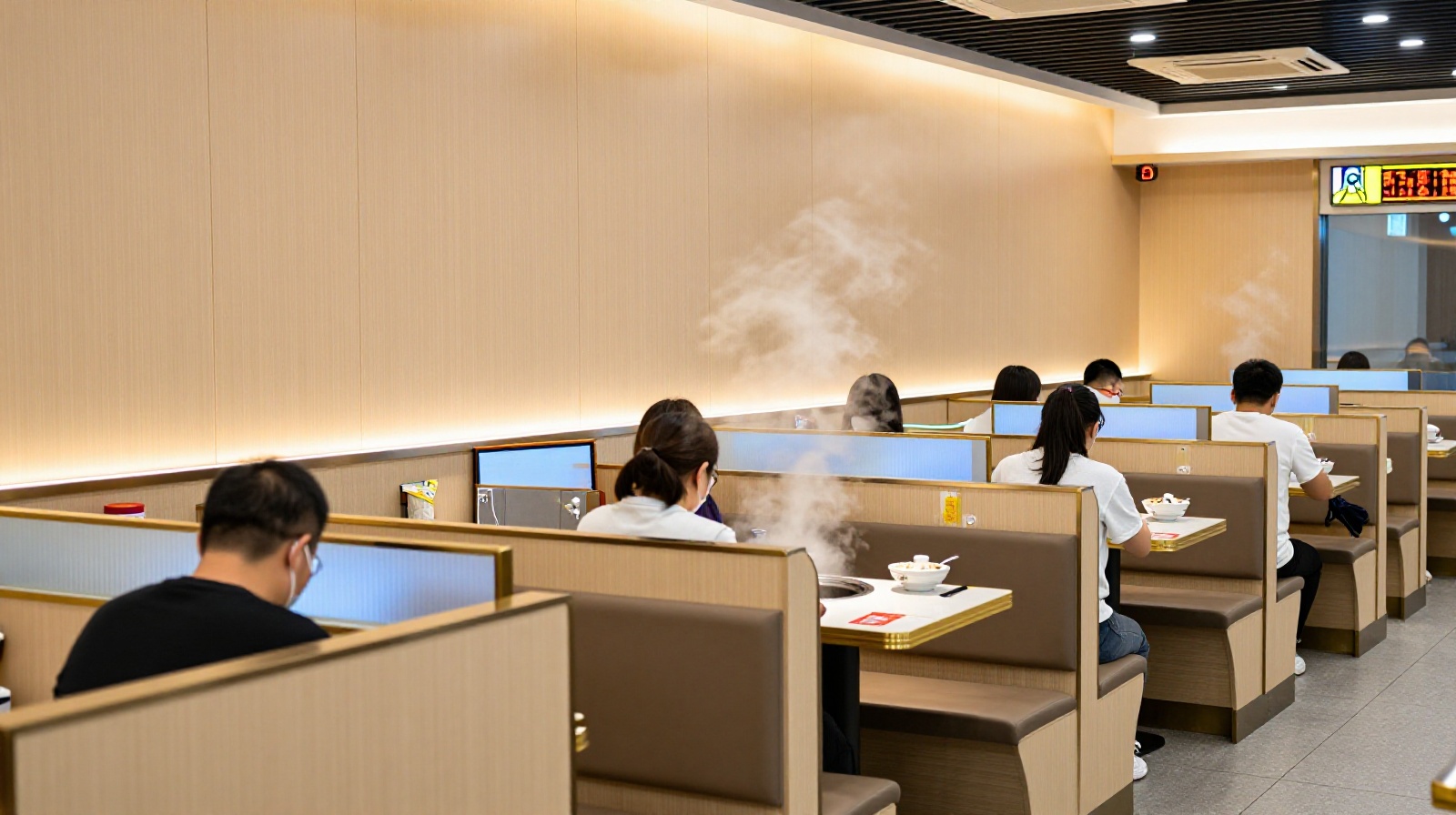 Modern solo dining restaurant interior with customers eating individually in partitioned booths
