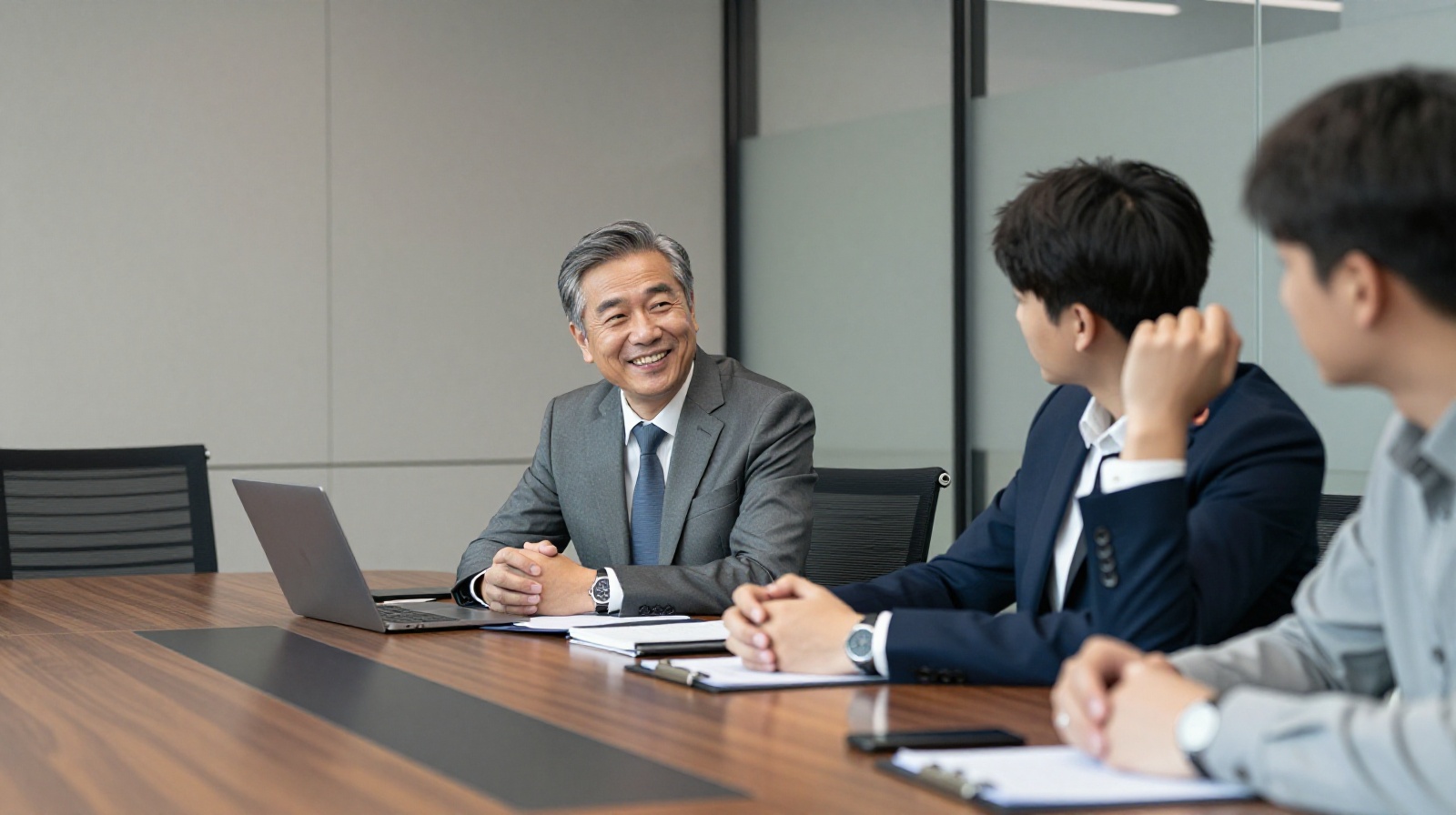 Business professionals in a modern Chinese office discussing respectfully, illustrating the social concept of saving face during negotiations.