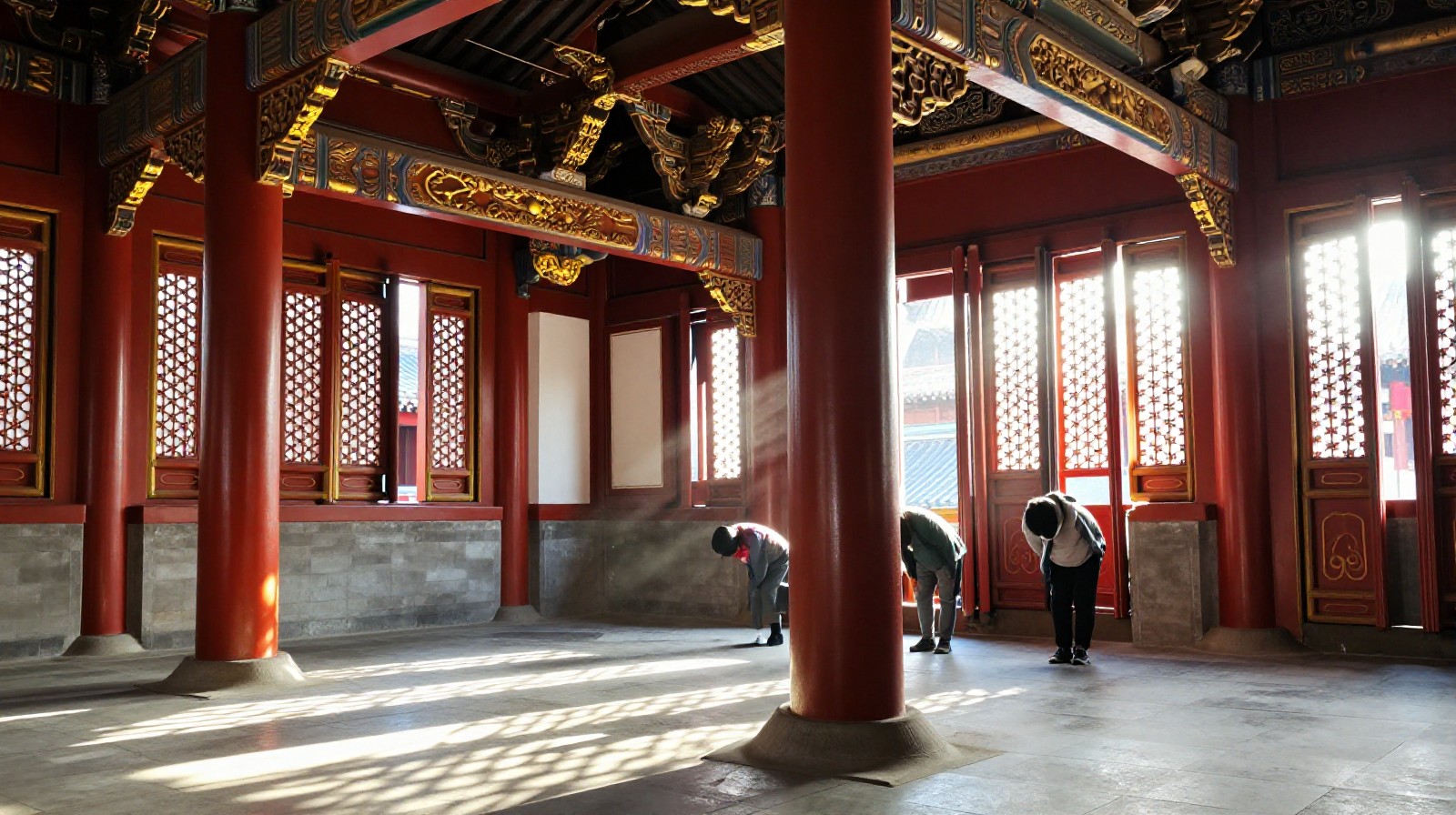 Red painted wooden pillars inside a traditional Chinese temple with sunlight streaming through