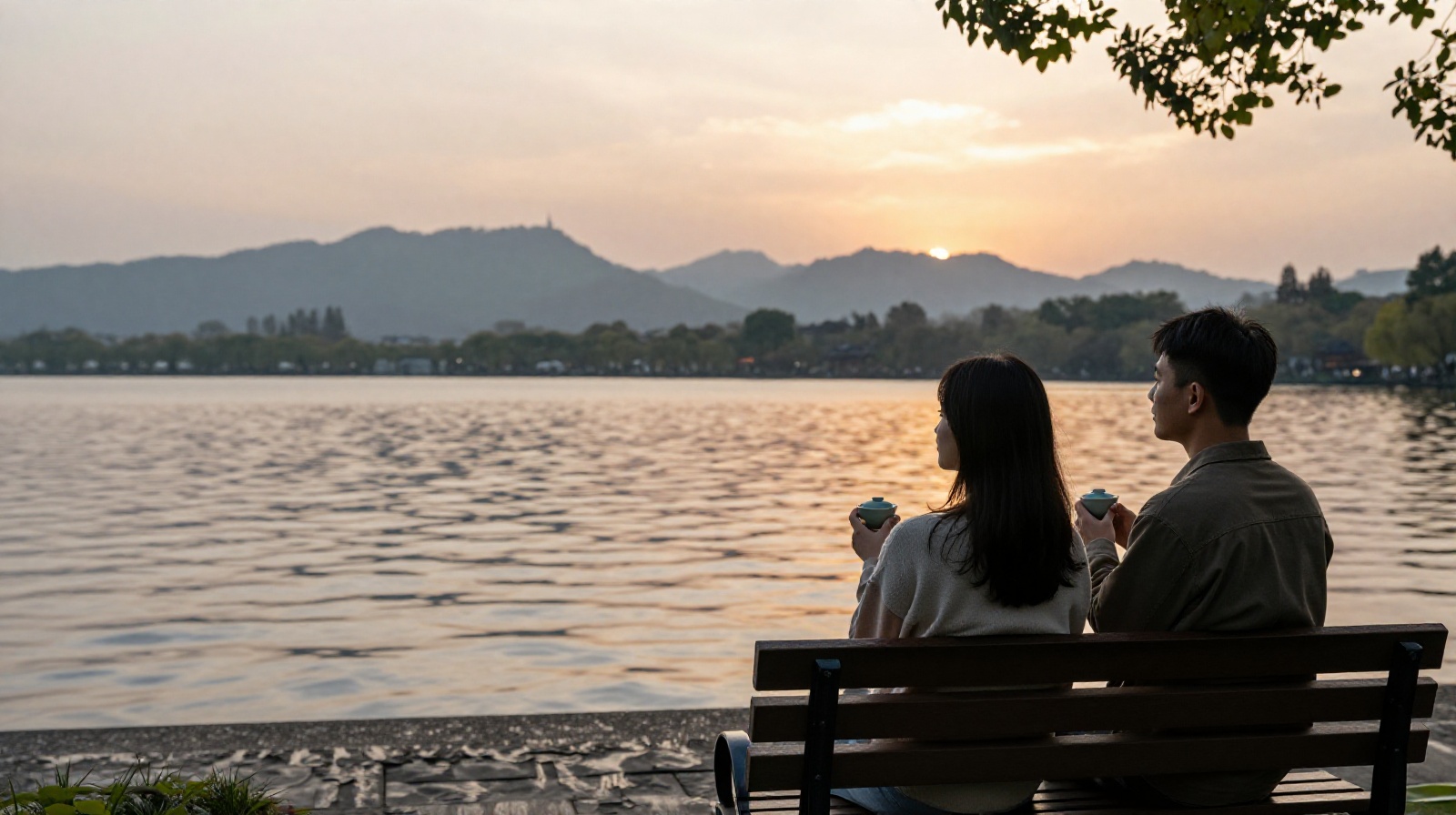 Young people relaxing in a park by a lake in Hangzhou, enjoying tea and the sunset in a moment of tranquility