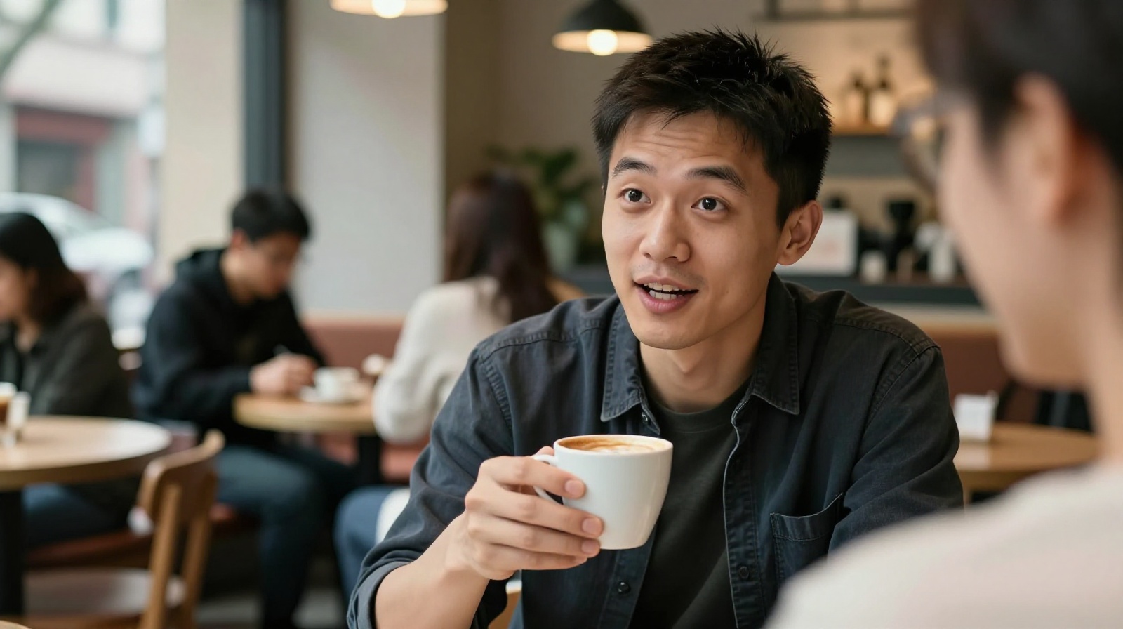 Young Chinese professional Li Wei chatting in a modern Shanghai coffee shop