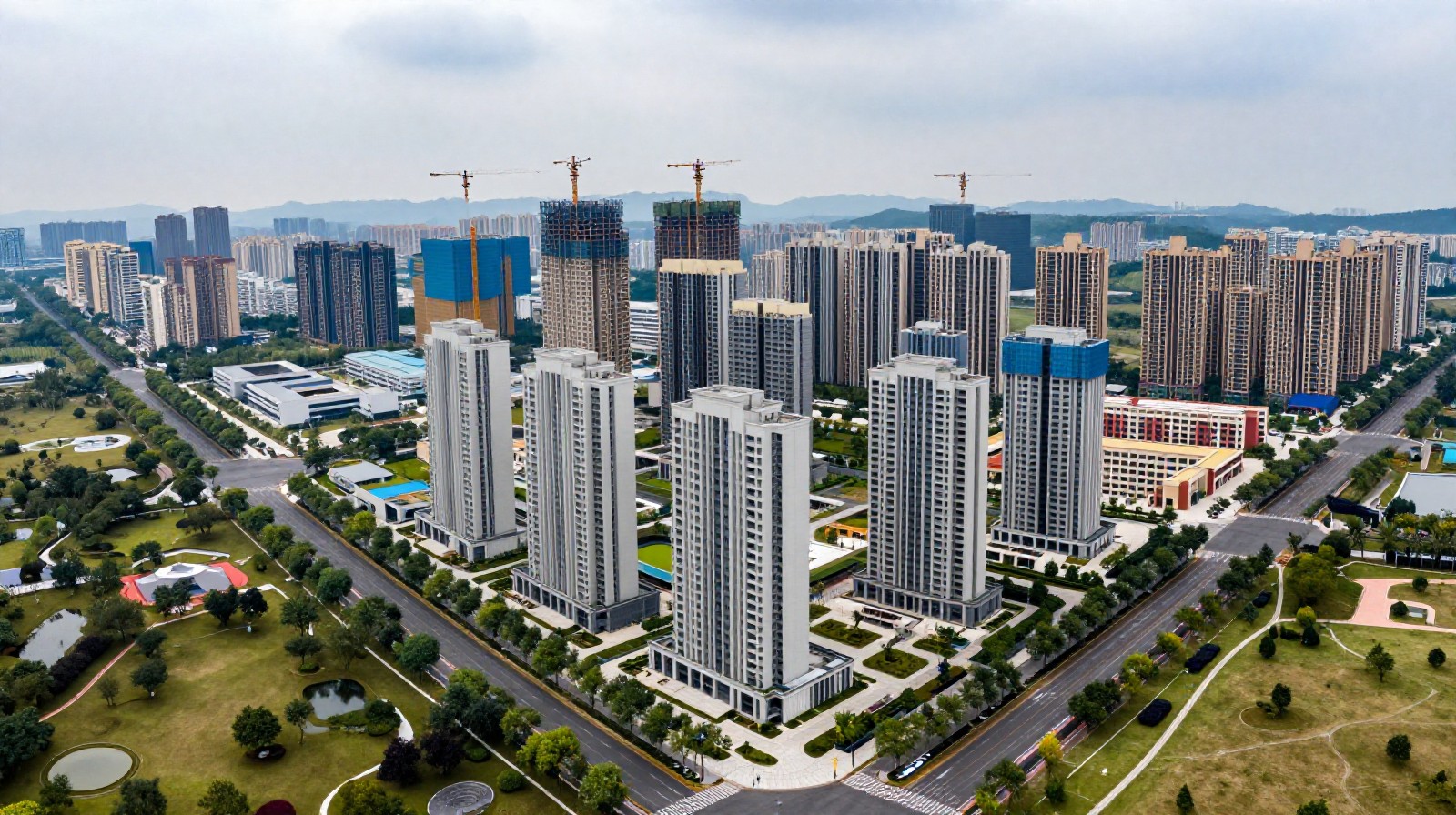 Aerial view of a rapidly developing urban district in China with new skyscrapers being built alongside completed parks and schools