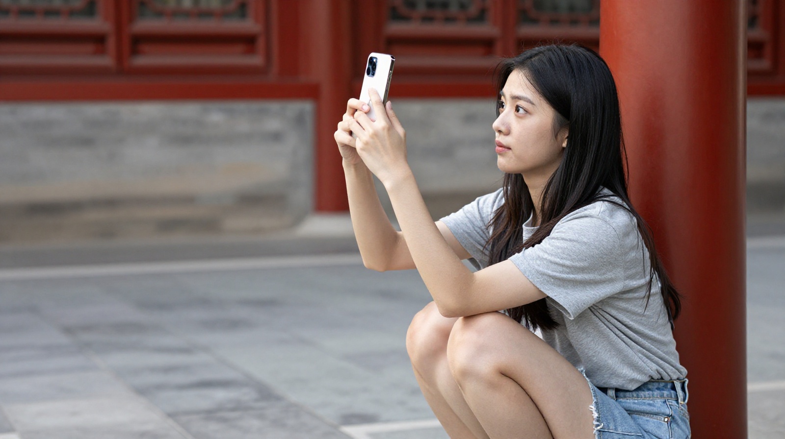 A Chinese tourist taking a self-portrait with a smartphone at the Forbidden City in Beijing
