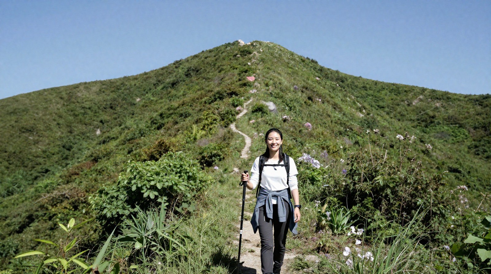 A young professional enjoying a hike in the mountains near Beijing on a sunny day.