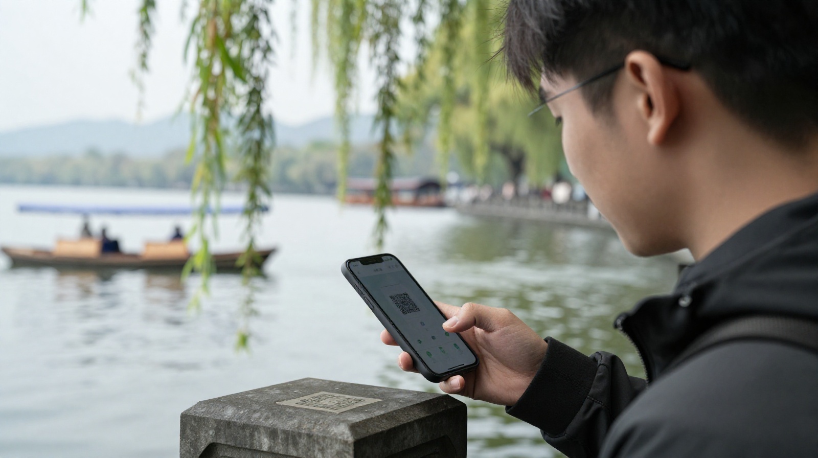 Young Hangzhou resident using mobile payment to buy a boat ticket at West Lake with ancient bridge in background
