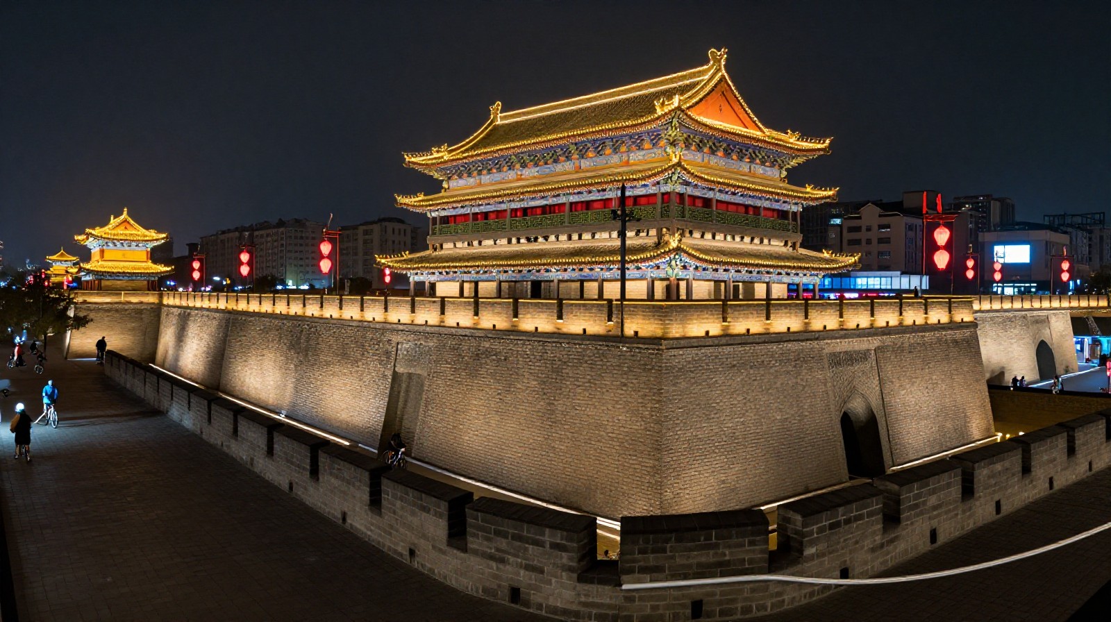 Cyclists and pedestrians enjoying the night view on top of the illuminated ancient city walls of Xi'an, demonstrating the integration of historical sites into modern recreational activities.