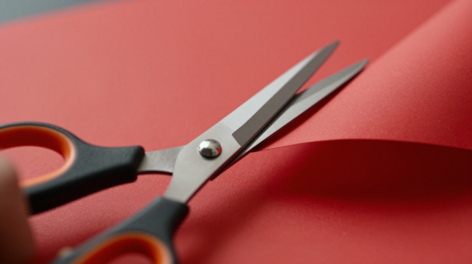 Extreme close-up of scissors cutting intricate red paper art