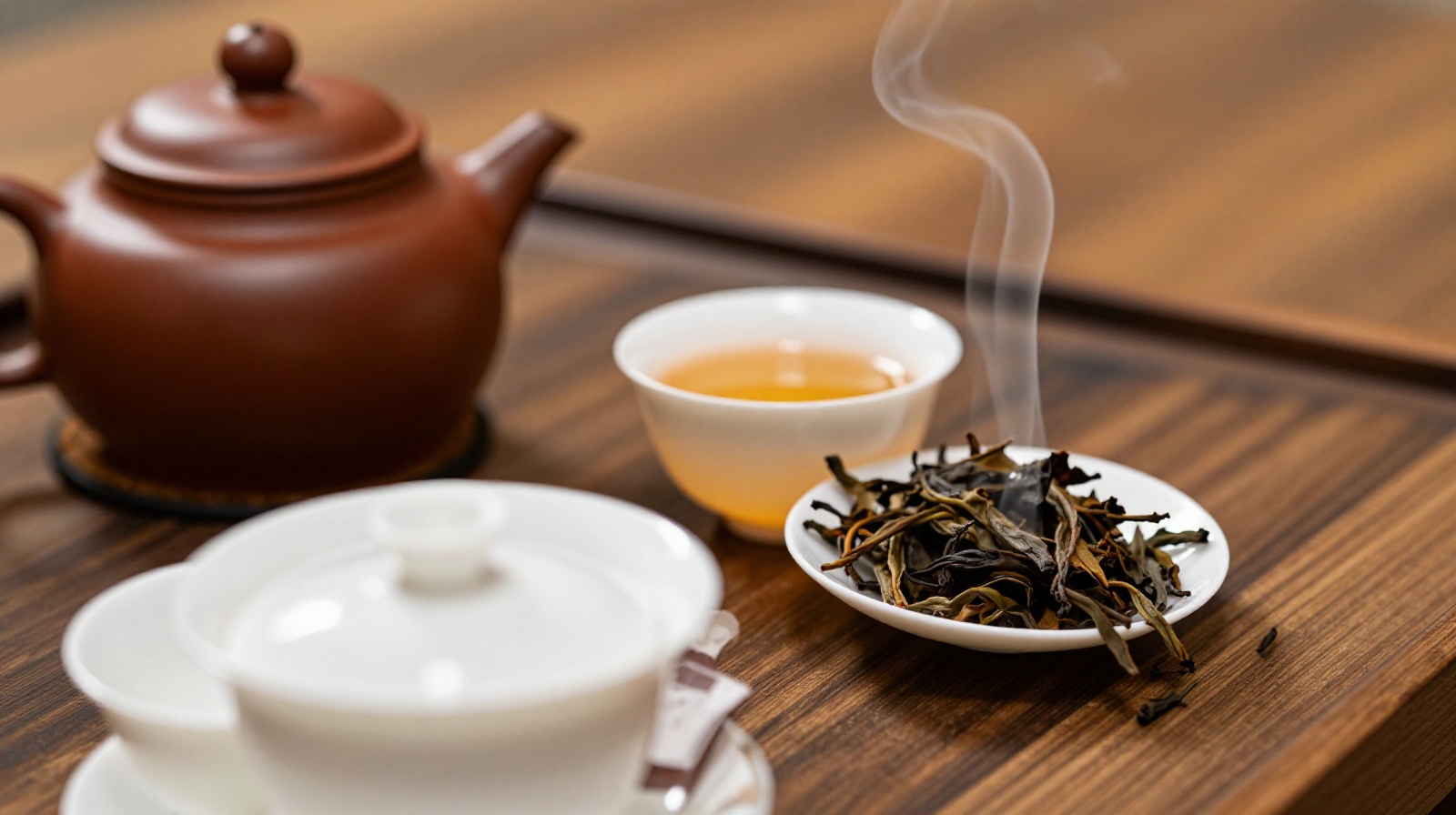 Close-up of a traditional Chinese Gongfu tea set with clay teapot and ceramic cups on a wooden table, steam rising from hot water.