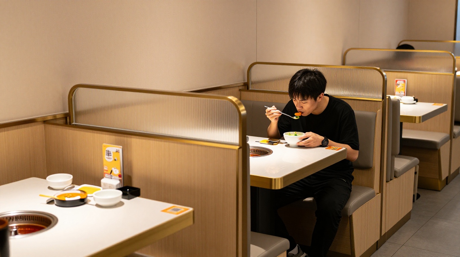 Solo diner enjoying a private meal at a restaurant with partitions