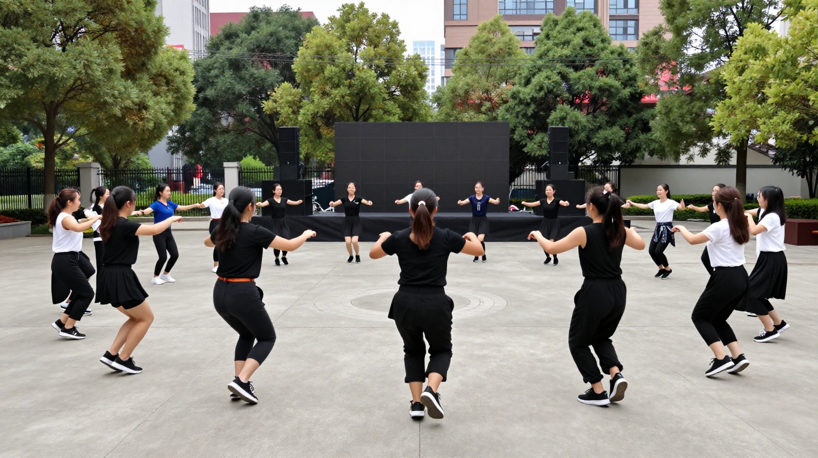 Back view of a large group of senior women performing square dancing in a public plaza in China.