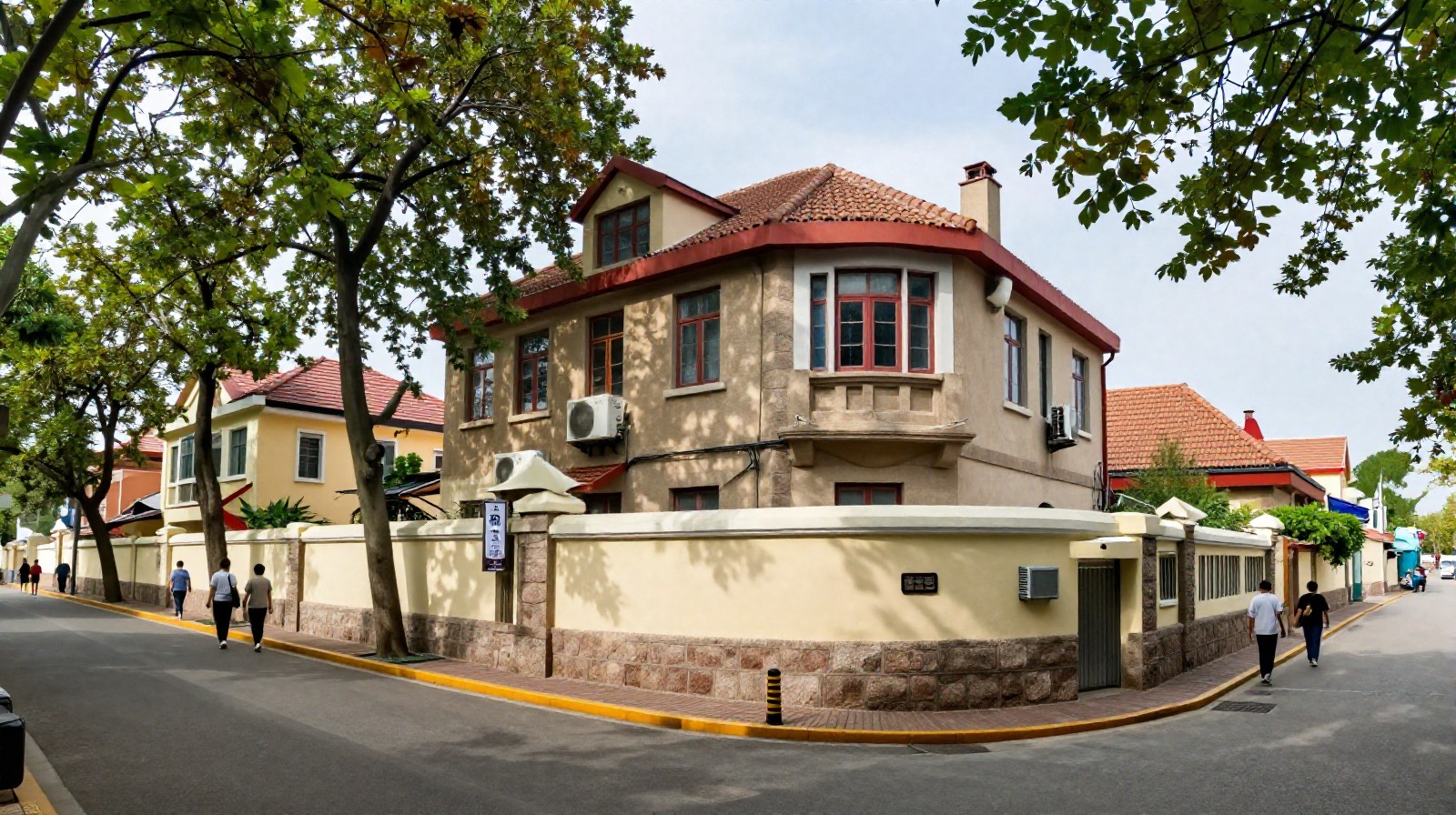 Sunny street scene in Qingdao's historic district featuring German-style architecture with red tiled roofs and local residents walking past cafes