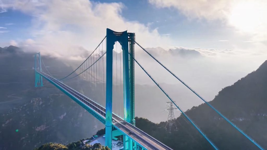 A local truck driver standing on the bridge deck of Huijiang Canyon in Guizhou looking out at the deep valley