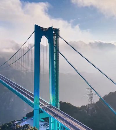 A local truck driver standing on the bridge deck of Huijiang Canyon in Guizhou looking out at the deep valley