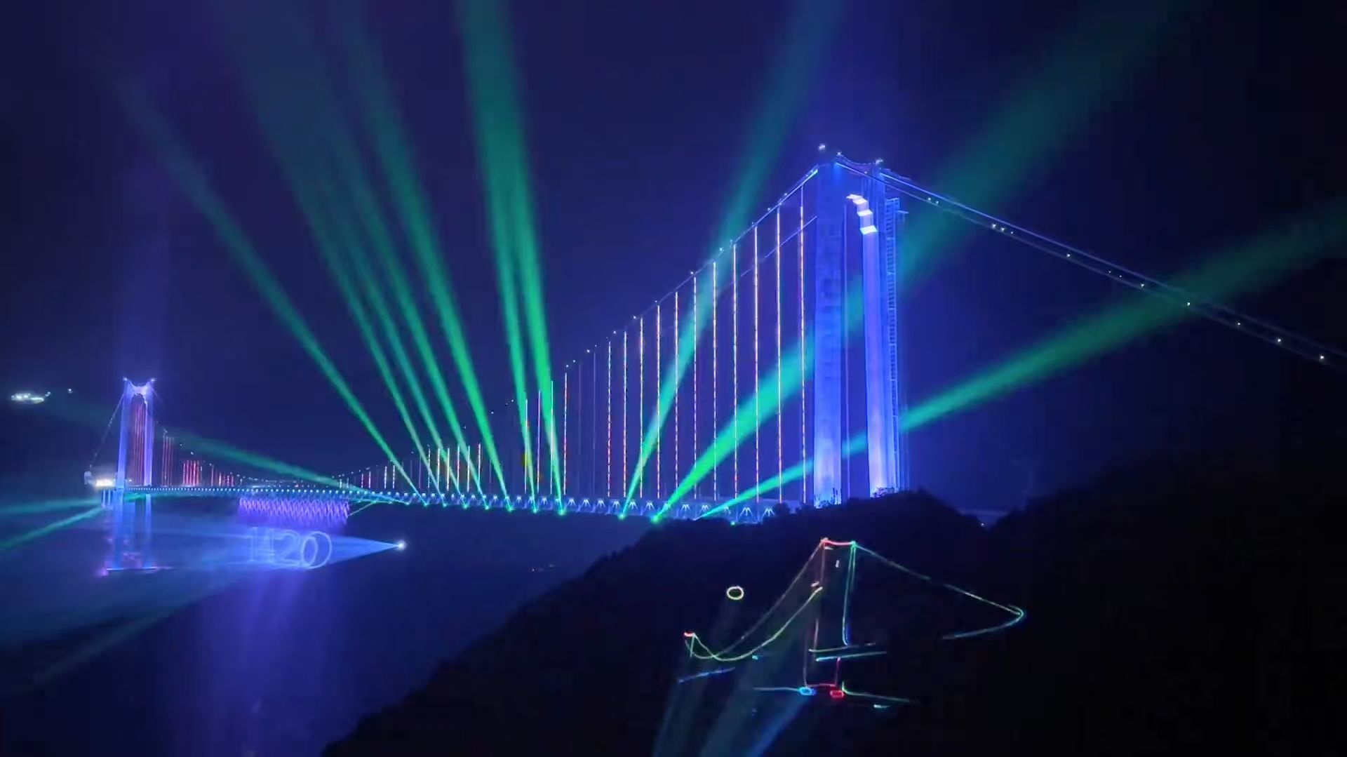 The Huijiang Canyon Bridge lit up at night spanning across the dark Guizhou mountains