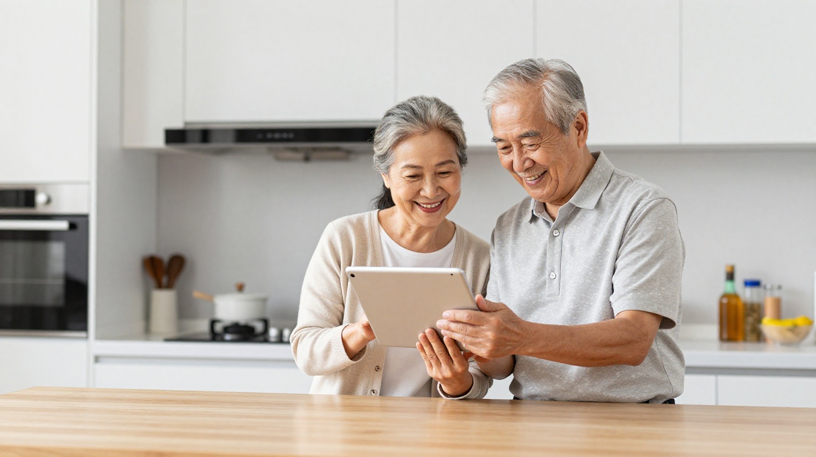 An elderly Chinese couple learning to use a tablet computer together in their kitchen, illustrating digital inclusion among seniors.