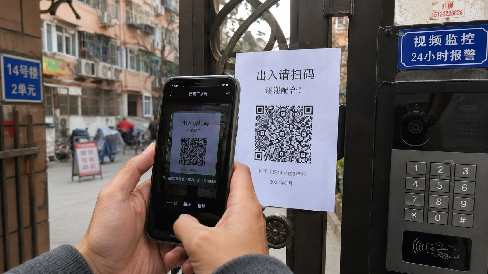 A resident scanning a landlord's rent payment QR code at the entrance of an apartment building in China.