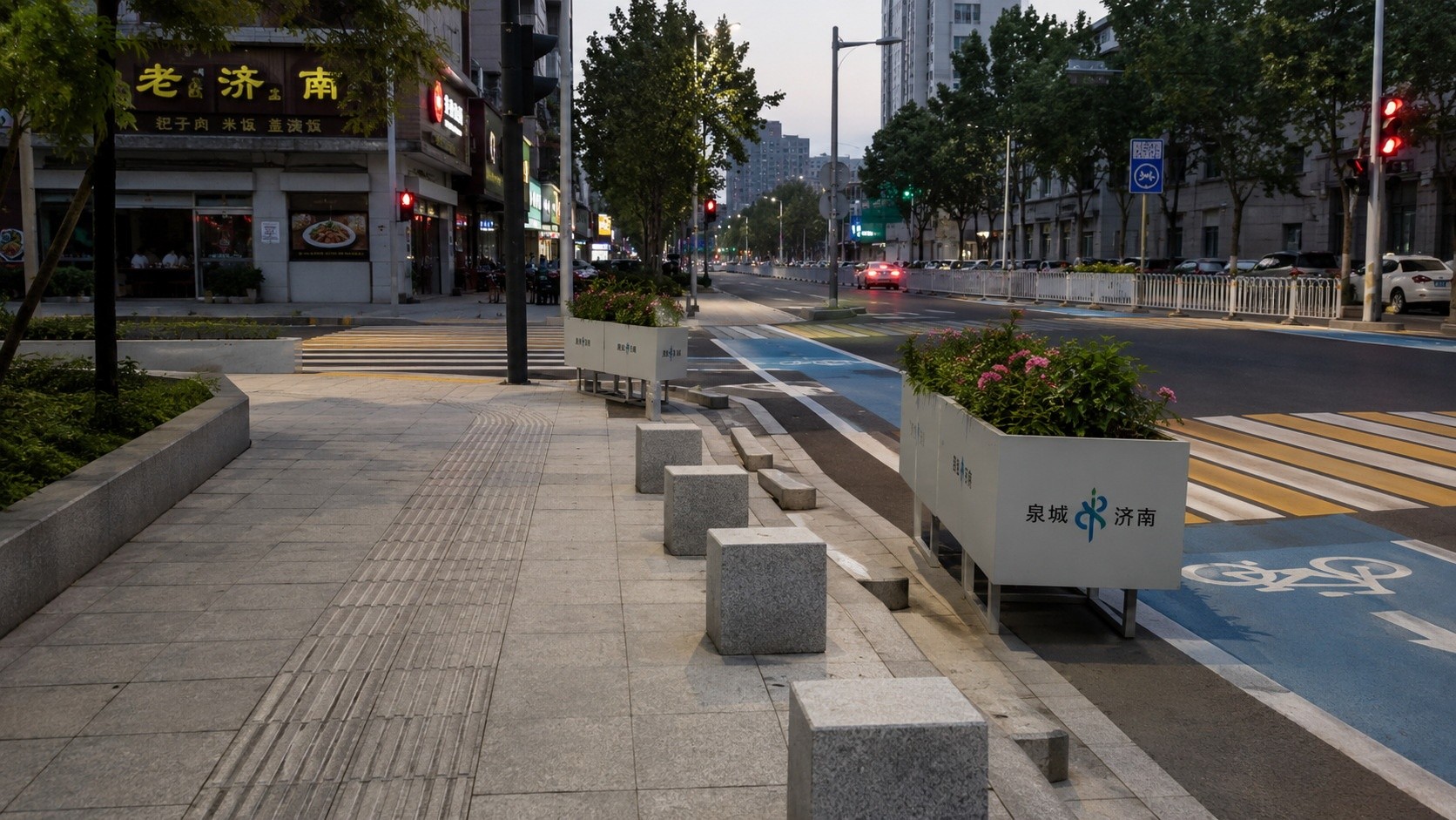 Side view of a Chinese street showing flexible urban design with planters and painted lines instead of metal guardrails to guide pedestrians and cyclists safely.