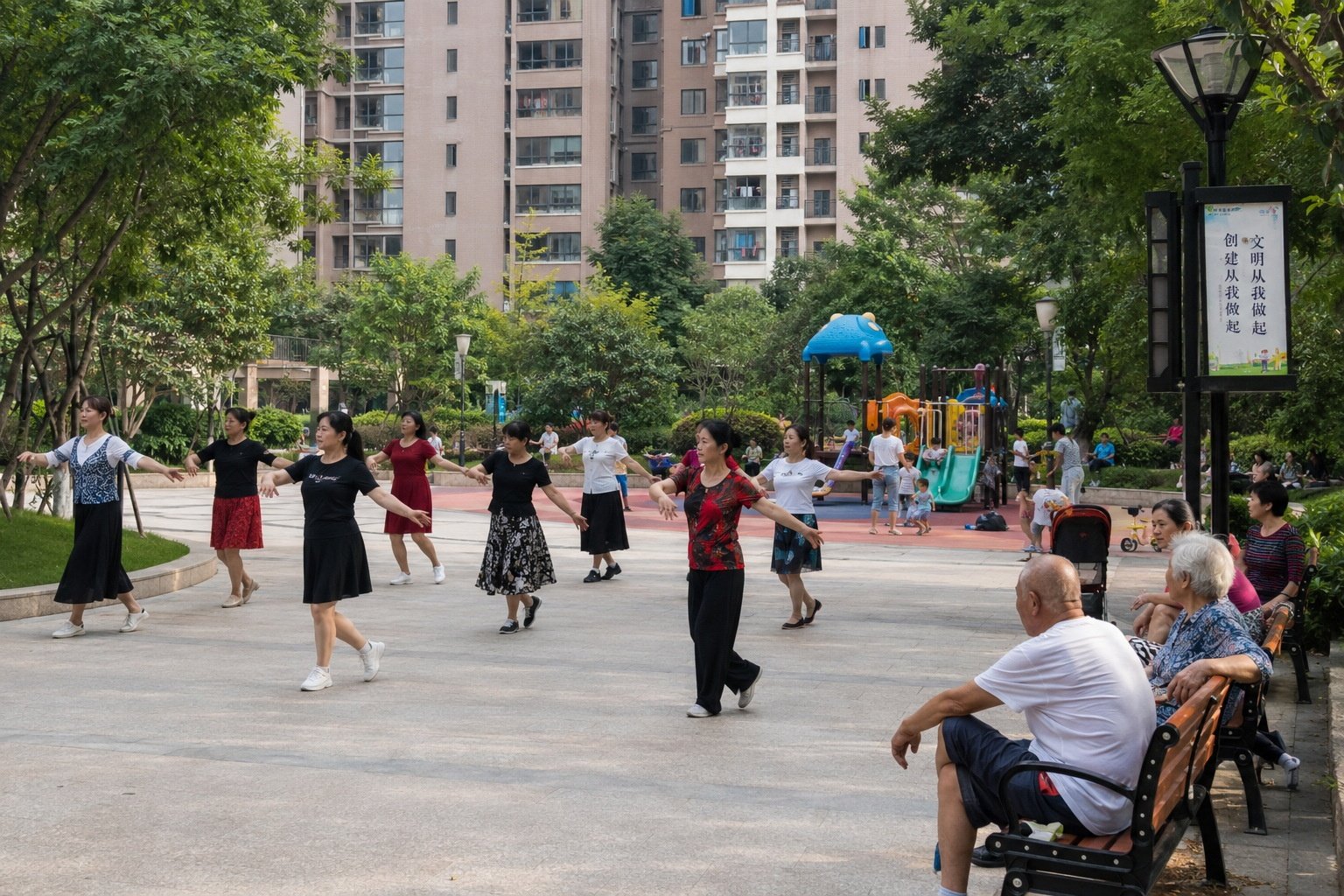 Residents performing square dancing in a public plaza inside a Chinese residential compound.