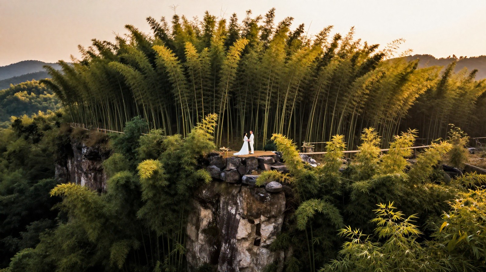 A wide landscape view of a wedding photoshoot location in nature, showing the couple standing far away to emphasize the scale of the environment.