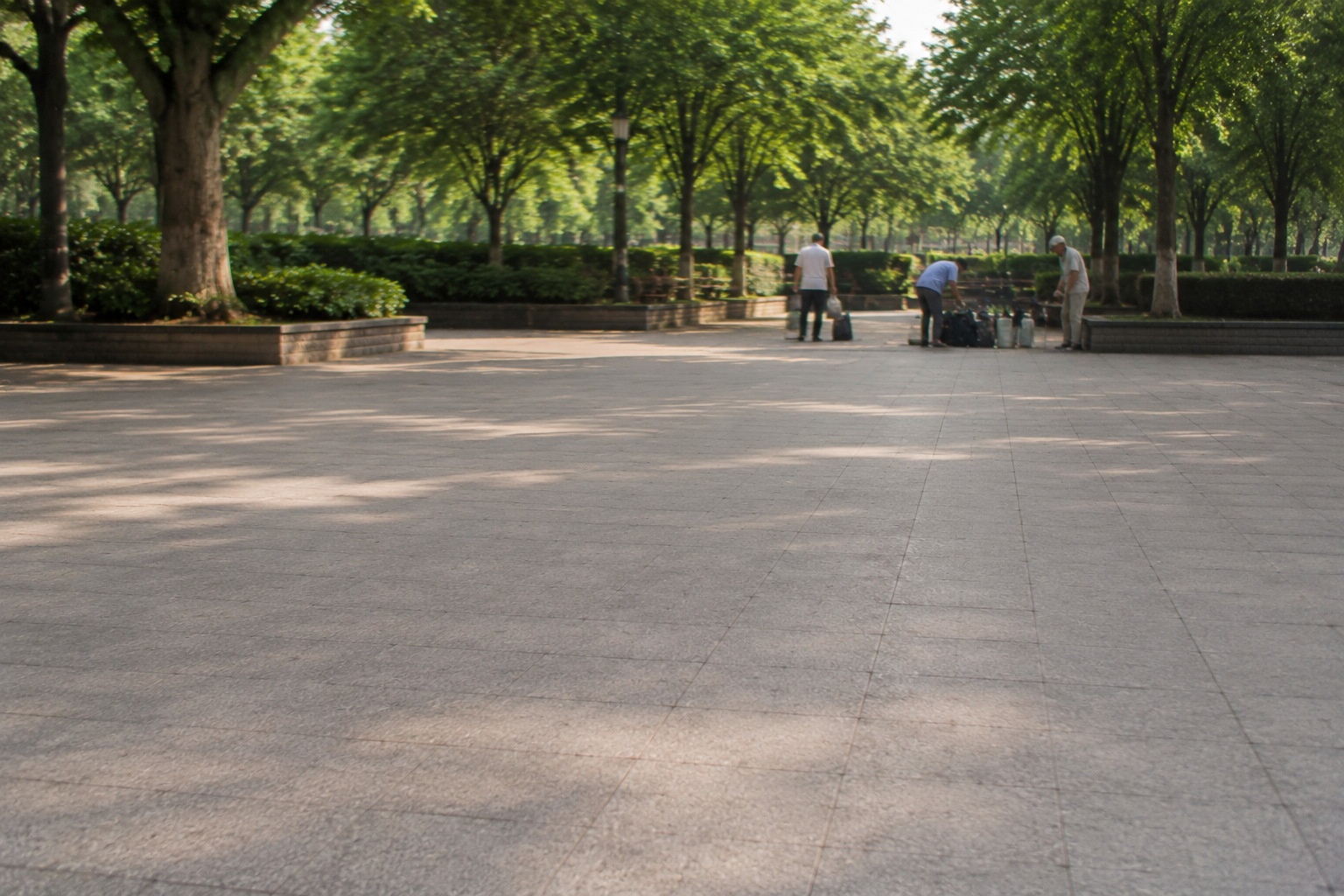 The empty park ground after the water calligraphy has evaporated, showing the ephemeral nature of the art