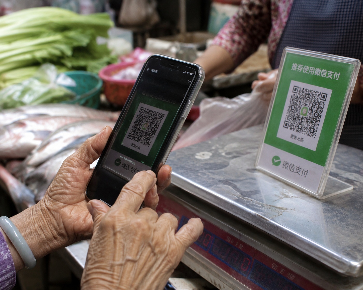 Elderly woman using mobile payment at a traditional wet market