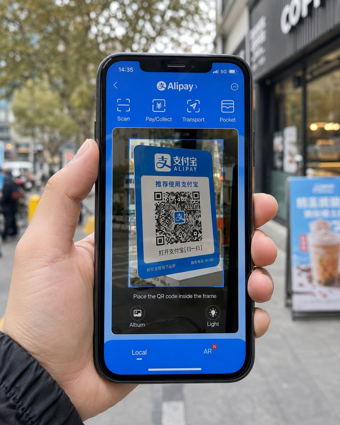 Close-up of a person using a smartphone to scan a payment QR code at a Chinese convenience store.
