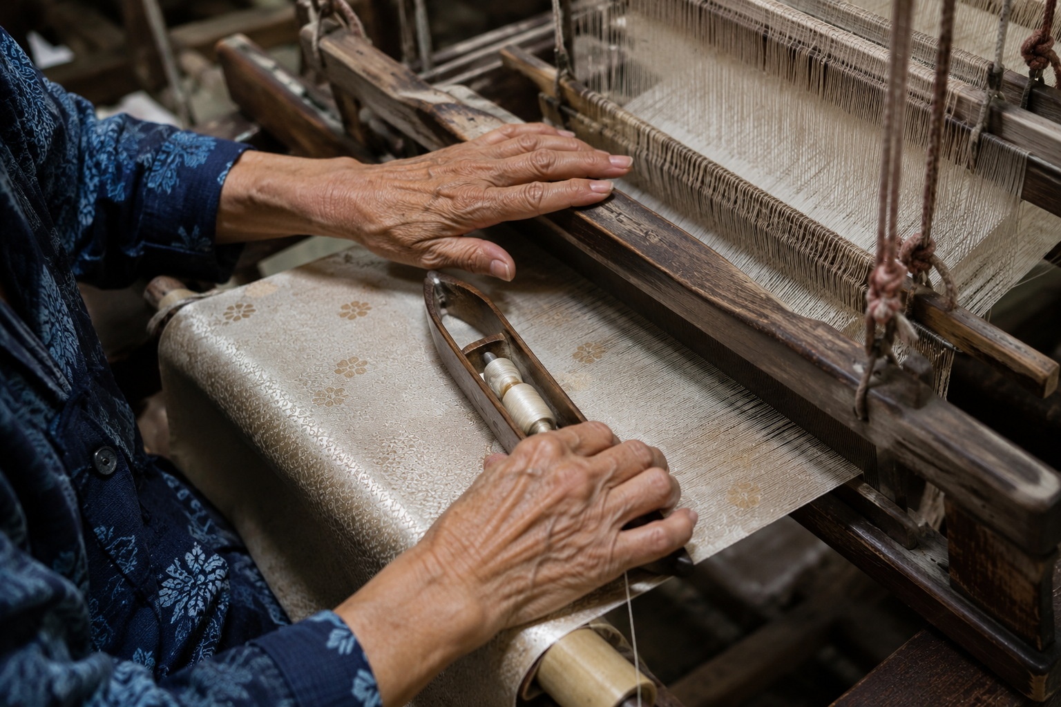 Close-up of traditional silk weaving process by a Chinese artisan, showing hands operating a wooden loom.