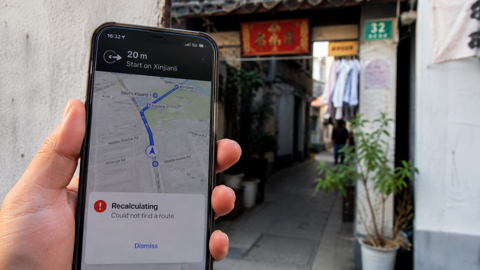 A person looking at a smartphone GPS that is recalculating while standing near the entrance of a traditional Chinese residential alley.