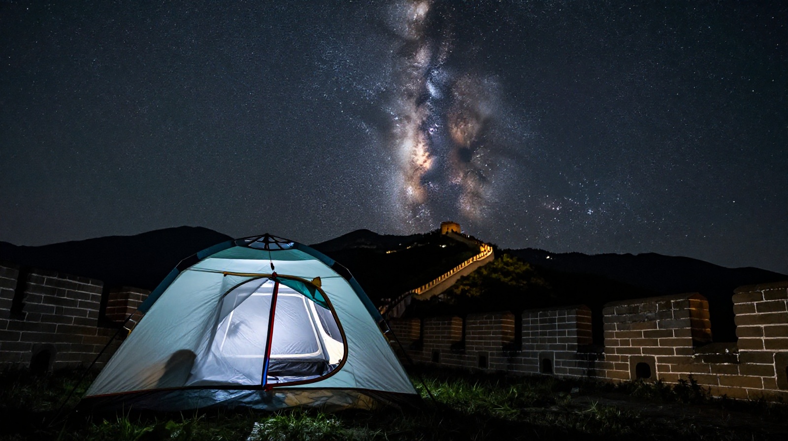 Night view from a campsite near the Wild Great Wall, showing a clear starry sky and the silhouette of the wall.