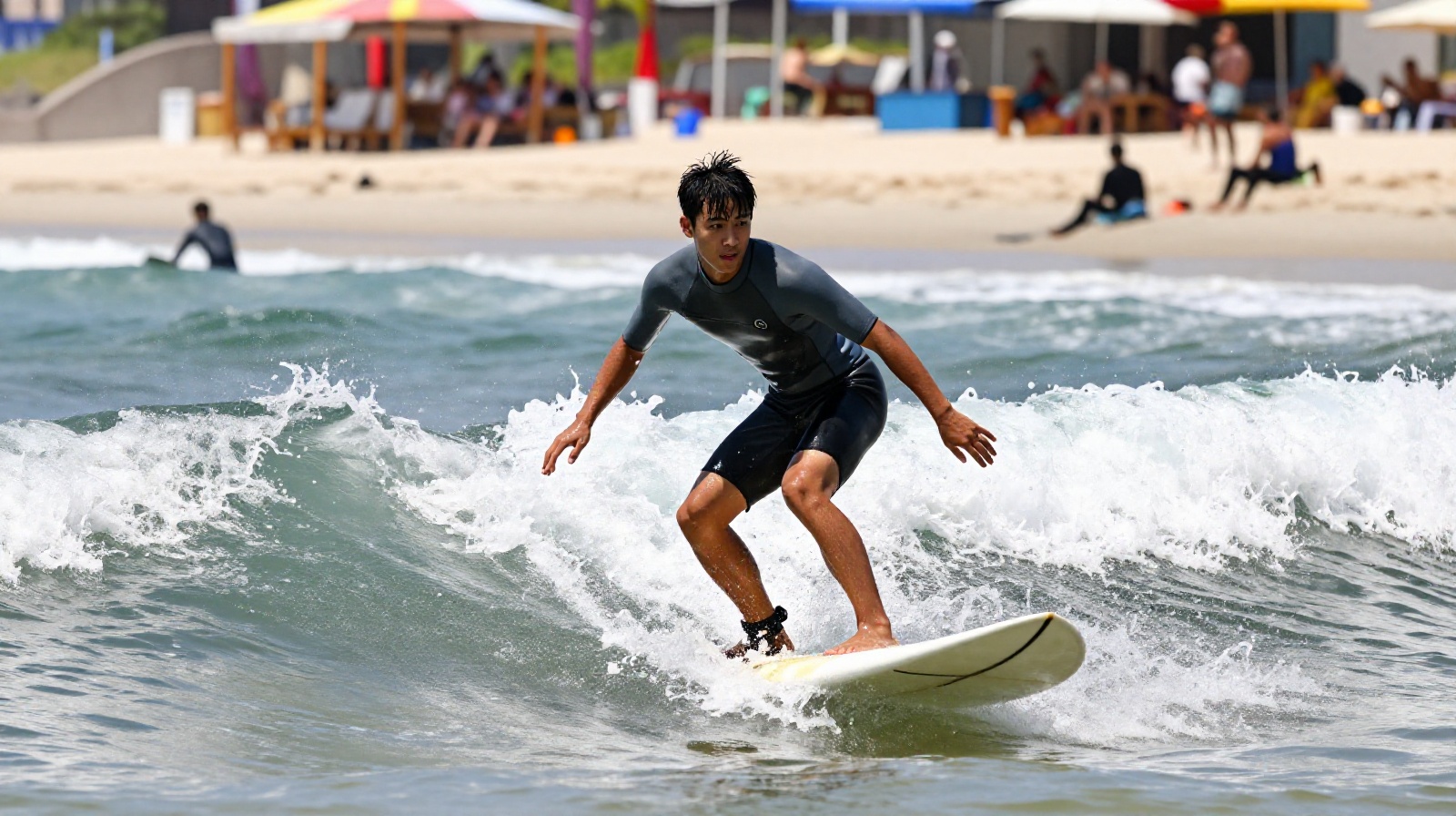 A young professional surfer riding a wave at Xichong Beach in Shenzhen, wearing a wetsuit and enjoying the ocean sport.