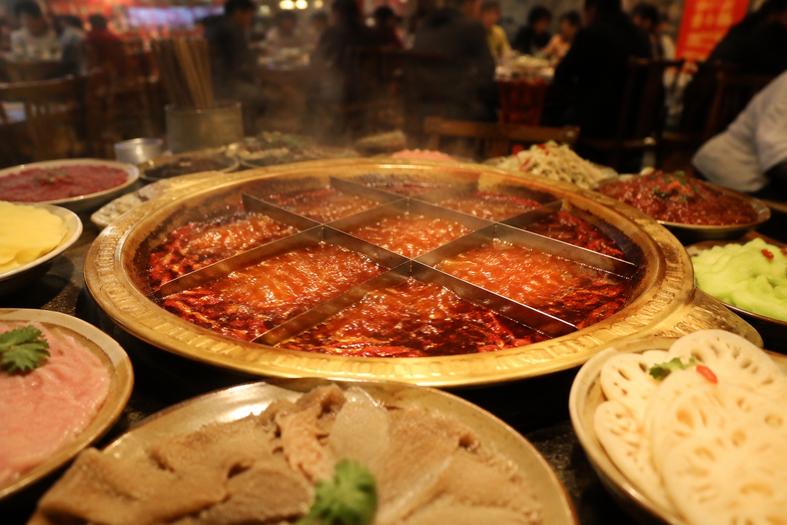 Close-up of a Chongqing nine-grid hotpot with red spicy broth and raw ingredients