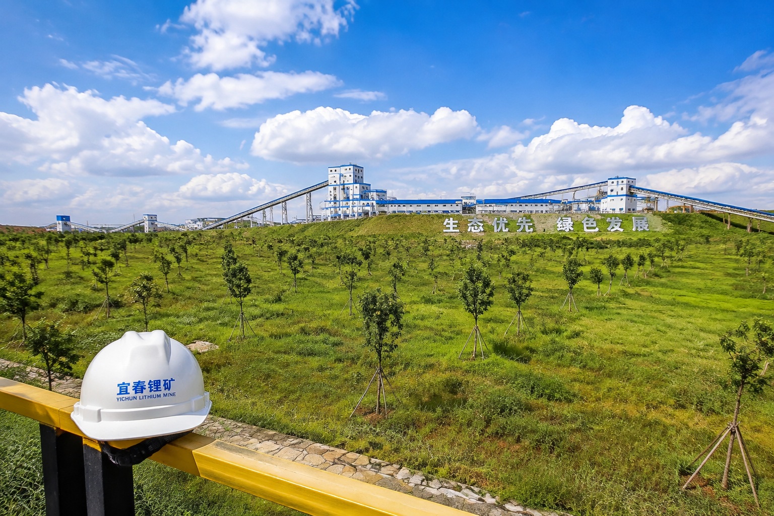 Restored vegetation on former lithium mine tailings in Yichun with processing plant in background