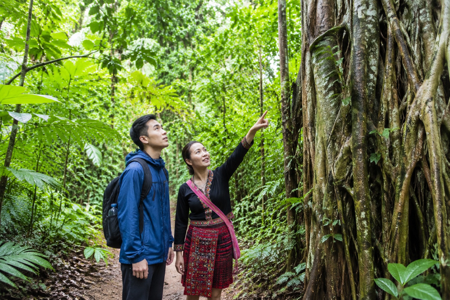 Trekking through Hainan tropical rainforest on a misty trail with a local guide