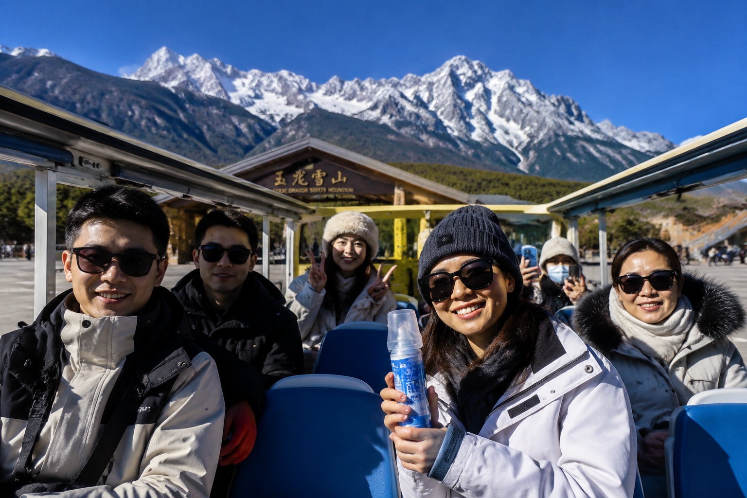 Tourists at the Jade Dragon Snow Mountain scenic entrance holding an oxygen canister before taking the shuttle.