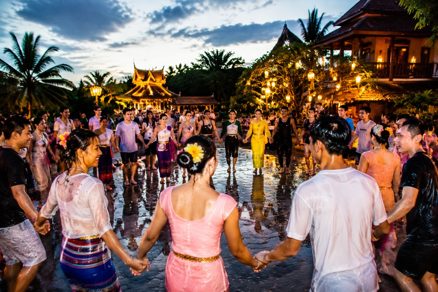 Villagers and tourists dance in a circle during Water Splashing Festival in Dehong