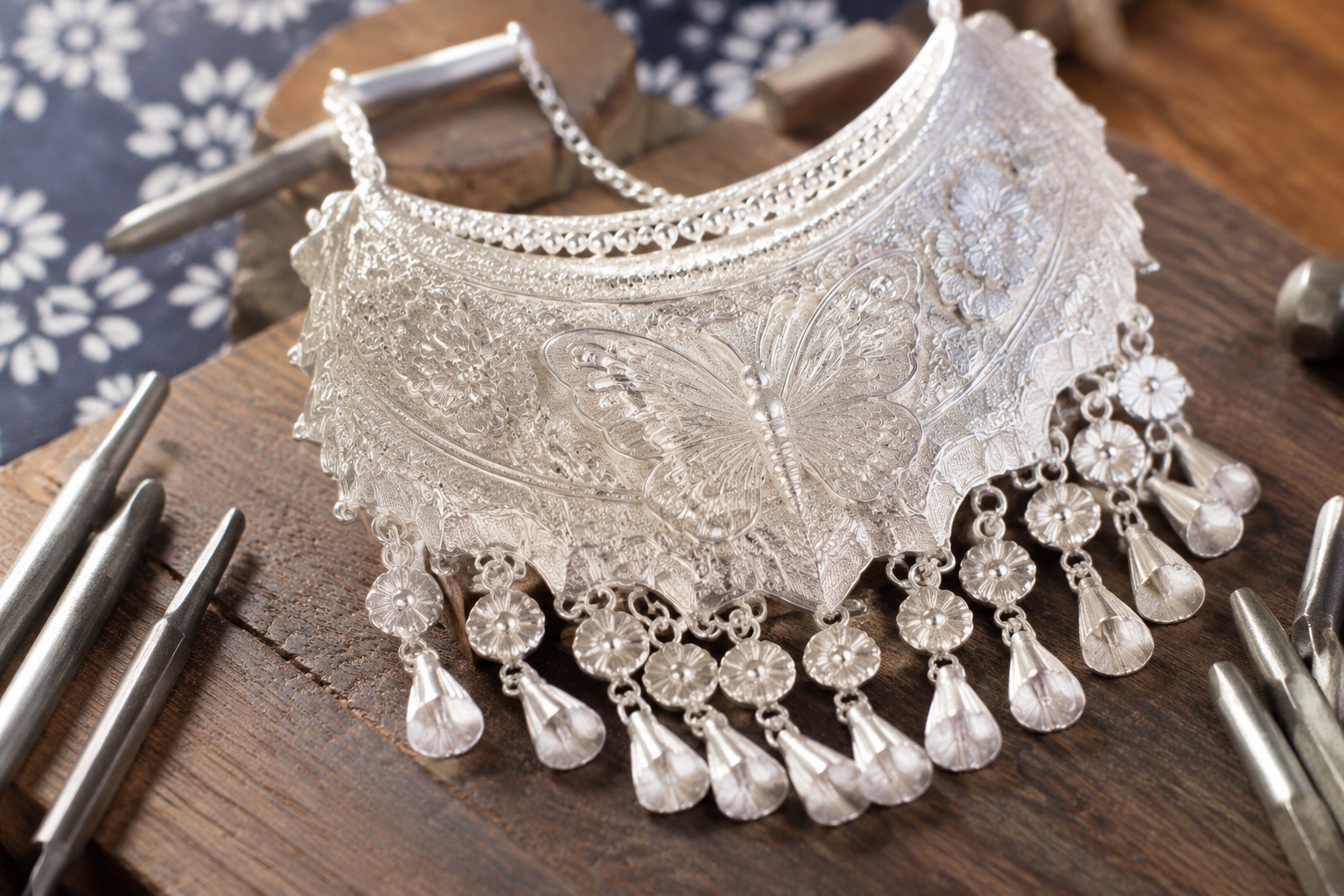 Close-up of handcrafted Miao silver ornament with butterfly and floral patterns