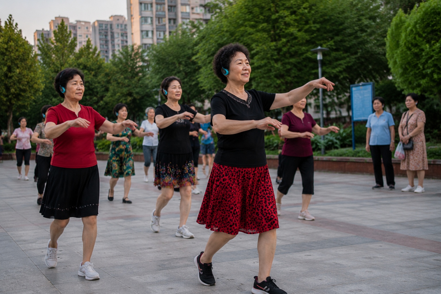 Elderly Chinese women wearing wireless headphones for silent square dancing in a Shanghai park