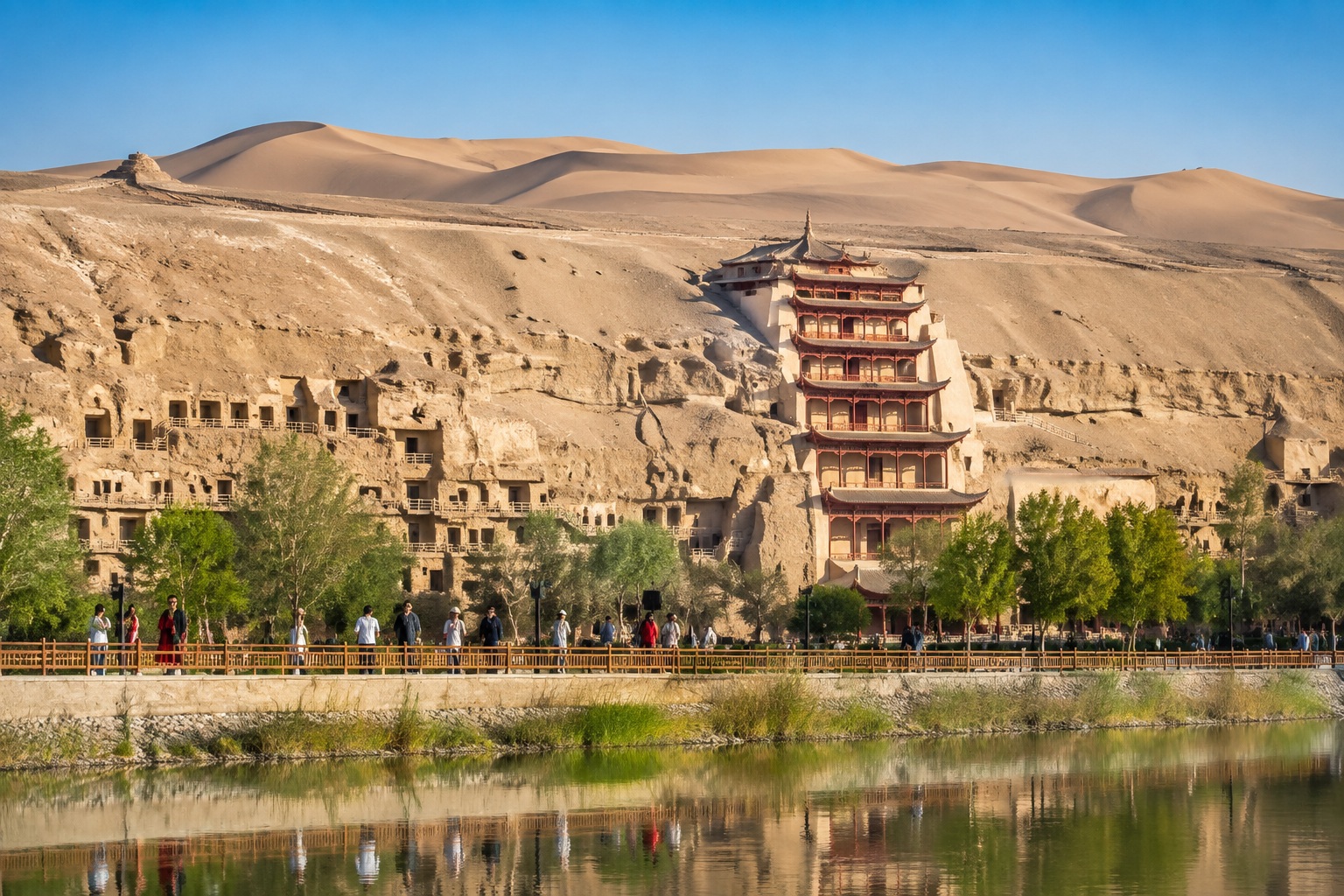 Panoramic view of the Mogao Caves cliff site in the Gobi Desert with a few tourists