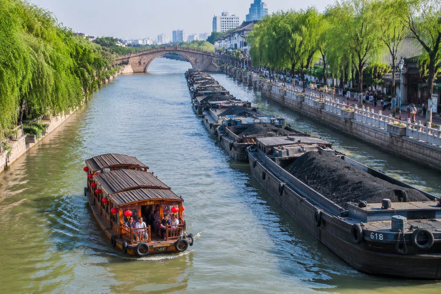 Tourist boat and cargo barges sharing the Grand Canal in Suzhou, with a stone bridge and riverside walking path