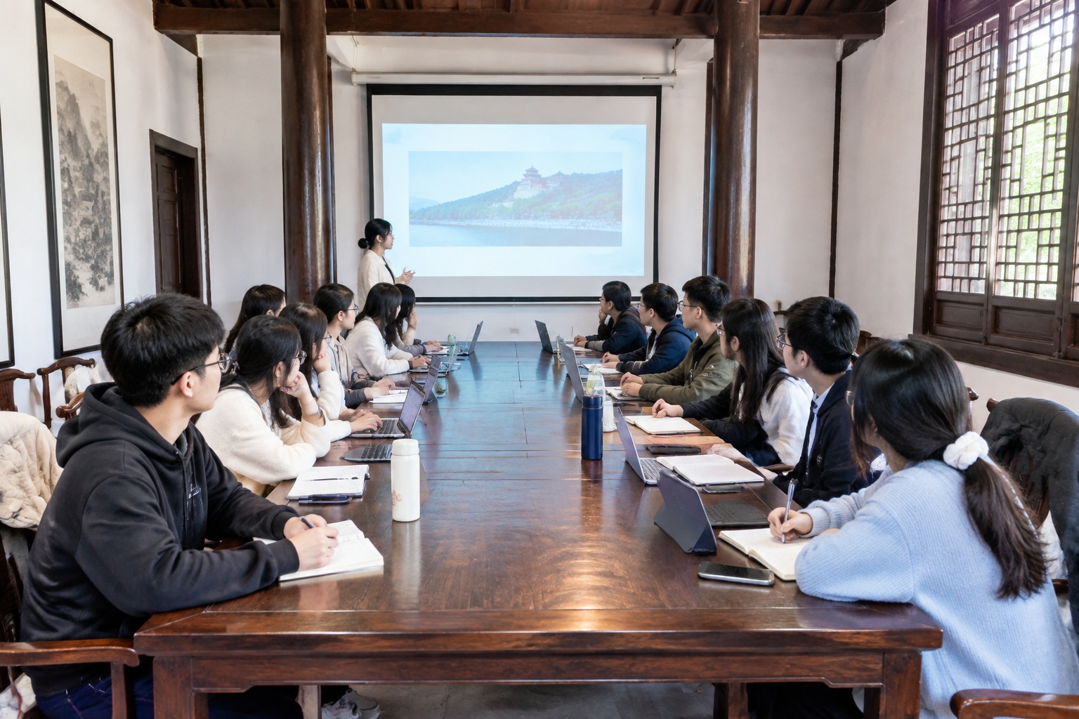 University students in a seminar class inside a historic wooden hall of Yuelu Academy in Changsha, laptops open on a long table