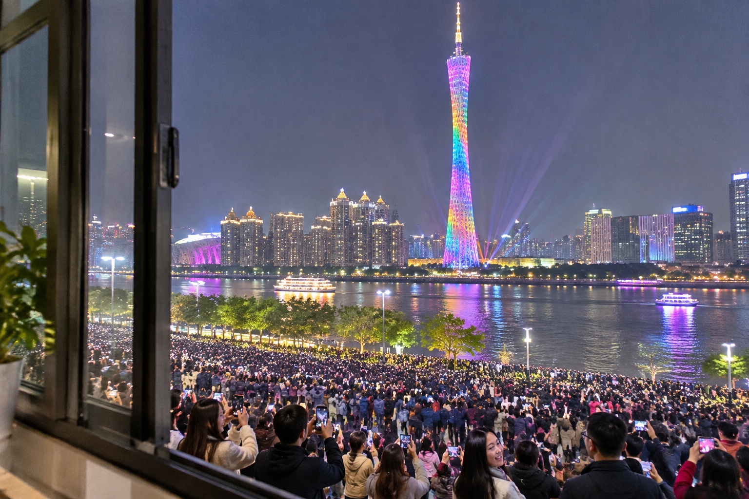 View from a Tianhe apartment balcony of Canton Tower's New Year's Eve light show and the crowd packed along the riverbank