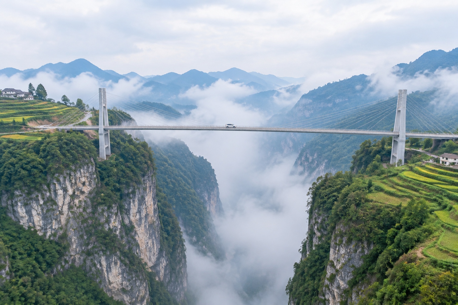 The Beipanjiang Bridge in Guizhou spanning a deep limestone gorge in morning mist, with terraced fields on the canyon rim.