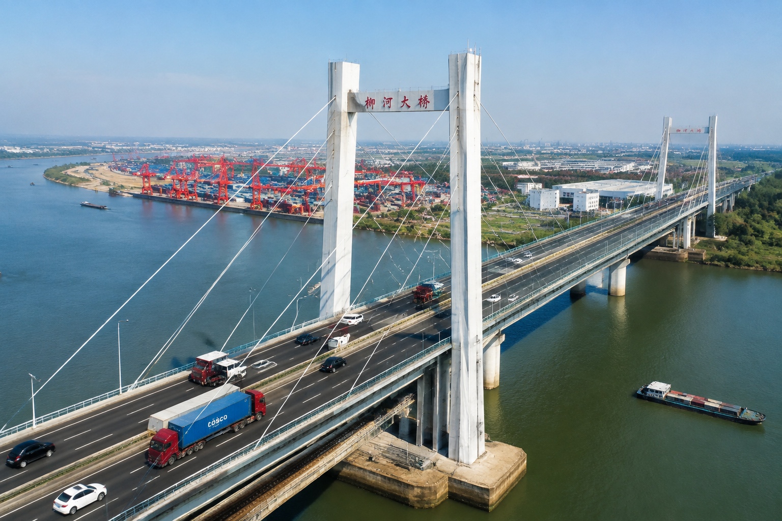 Aerial view of traffic on the highway deck of the Shanghai-Suzhou-Nantong Yangtze River Bridge with a river port on the far bank