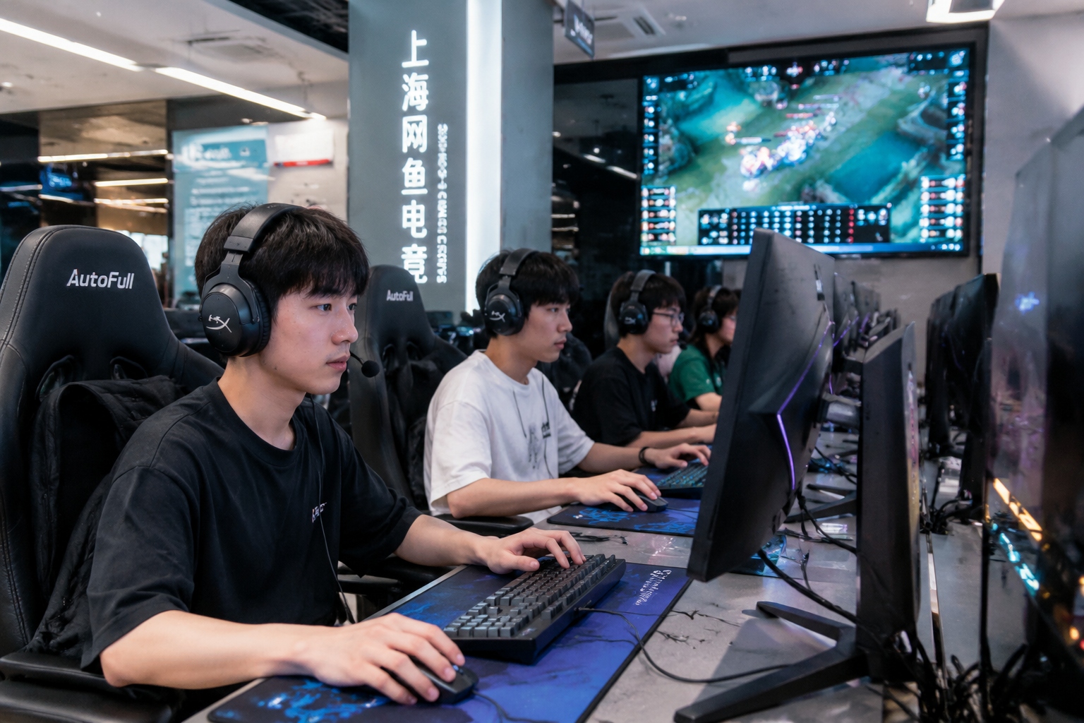 Young gamers playing at high-end computers in a bright, modern Shanghai internet cafe with a large screen displaying an esports tournament