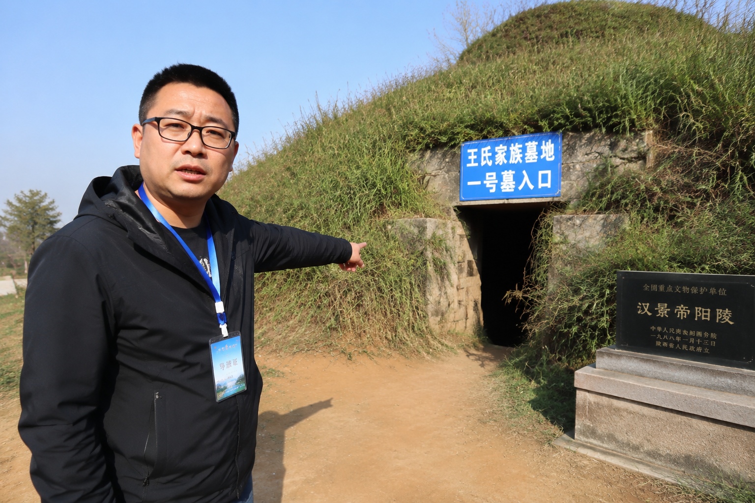 A local guide in Shaanxi pointing out the location of an ancient sealed tomb on a rural hillside
