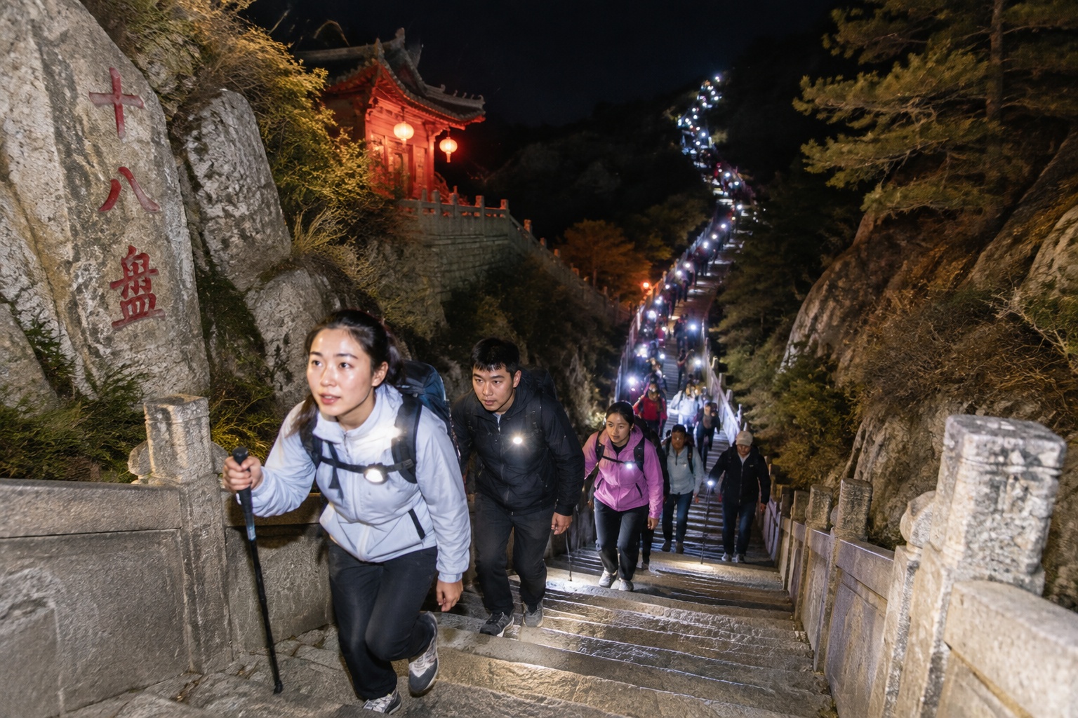 A long column of night climbers with flashlights crowded on the steep Eighteen Bends stone staircase of Mount Tai