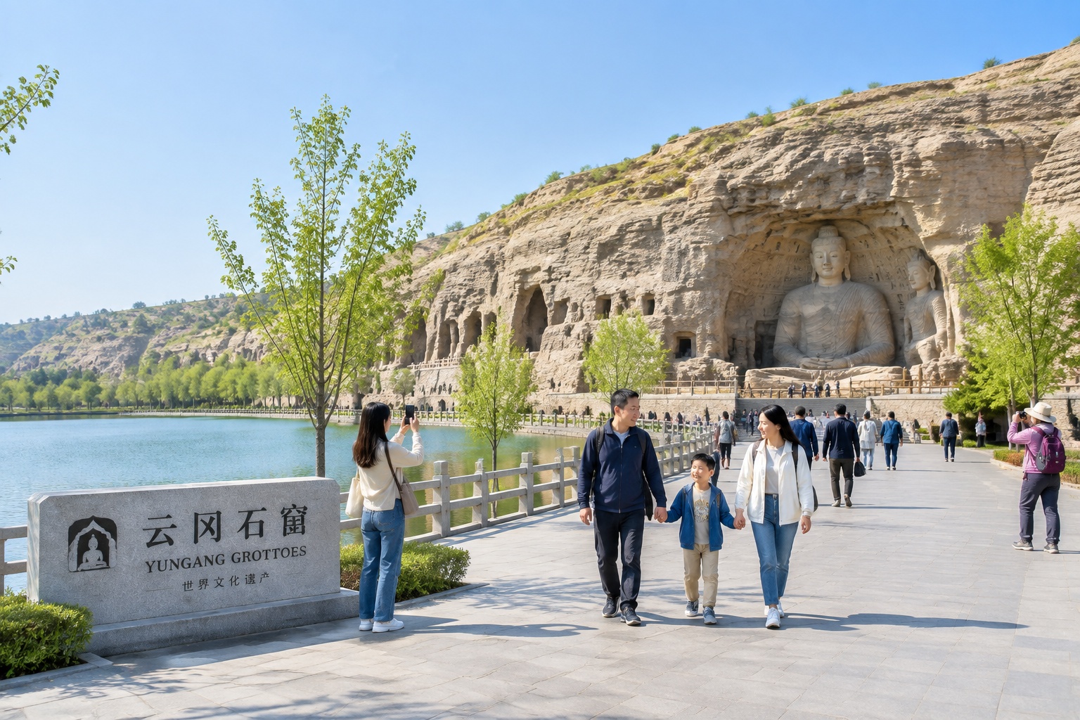 The modern park and lake in front of the Yungang Grottoes cliff near Datong, with visitors walking toward the cave entrances